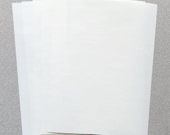 May include: A stack of multiple rectangular sheets of white paper. The paper has a smooth, opaque surface and is arranged in a slightly fanned-out pile, showing the clean, straight edges of each individual sheet stacked together.