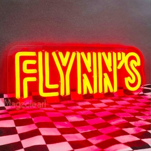 May include: A red neon sign with the word "FLYNN'S" in yellow neon letters. The sign is on a checkered background.