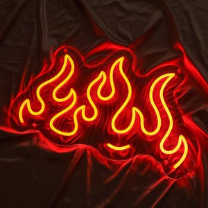 May include: Yellow neon flame sign with a red glow. The sign is shaped like a series of flames.
