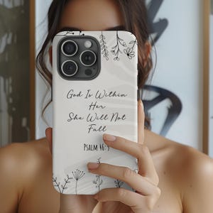 May include: White phone case with a black and white floral design and the text "God Is Within Her She Will Not Fall Psalm 46:5".