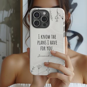 May include: White phone case with a floral design and the text "I know the plans I have for you. Jeremiah 29:11" in black.