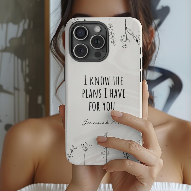 May include: White phone case with a floral design and the text "I know the plans I have for you. Jeremiah 29:11" in black.