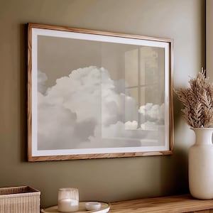 May include: A framed print of a cloudy sky with a window reflection. The frame is made of light brown wood and the print is in shades of gray and white.