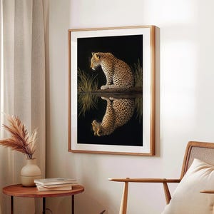 May include: A framed print of a leopard sitting in a body of water, looking to the left. The leopard's reflection is visible in the water.