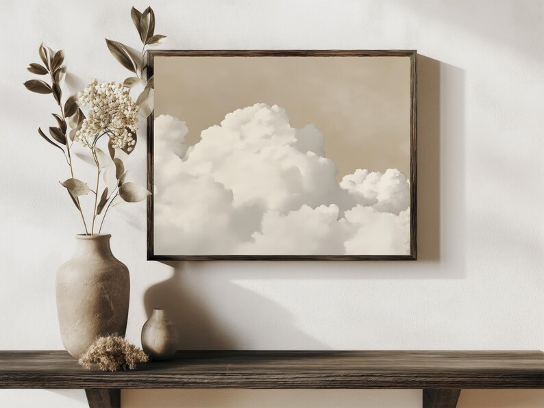 May include: A framed print of a beige and white cloudy sky. The print is hanging on a white wall above a wooden shelf with a brown vase and a small brown vase.