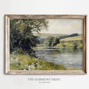 Pu&ograve; includere: Un dipinto incorniciato di una scena paesaggistica con un fiume, alberi e colline ondulate. Il dipinto &egrave; in una cornice di legno chiaro e ha un aspetto vintage.