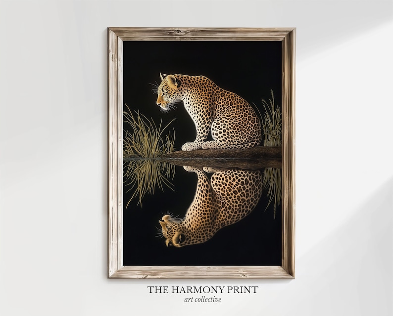 May include: A framed print of a leopard sitting by a body of water, looking at its reflection. The leopard is brown and black with spots. The background is black with green grass.