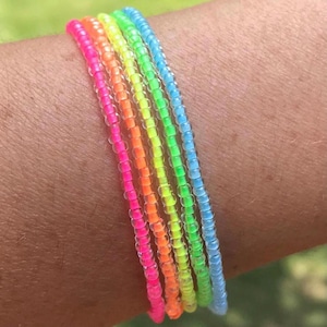Pulseras luminosas de cuentas diminutas de neón: joyas apilables de colores arcoíris, brillo intenso y vibrante.