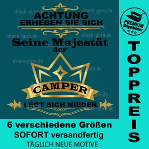 May include: A teal blue background with a gold crown and the text "ACHTUNG ERHEBEN SIE SICH Seine Majestät der CAMPER LEGT SICH NIEDER" in black. The text "TOPPREIS" is in black and vertical on the right side of the image. The image also includes a gold star and a gold ribbon. The text "6 verschiedene Größen SOFORT versandfertig TÄGLICH NEUE MOTIVE" is in black at the bottom of the image.