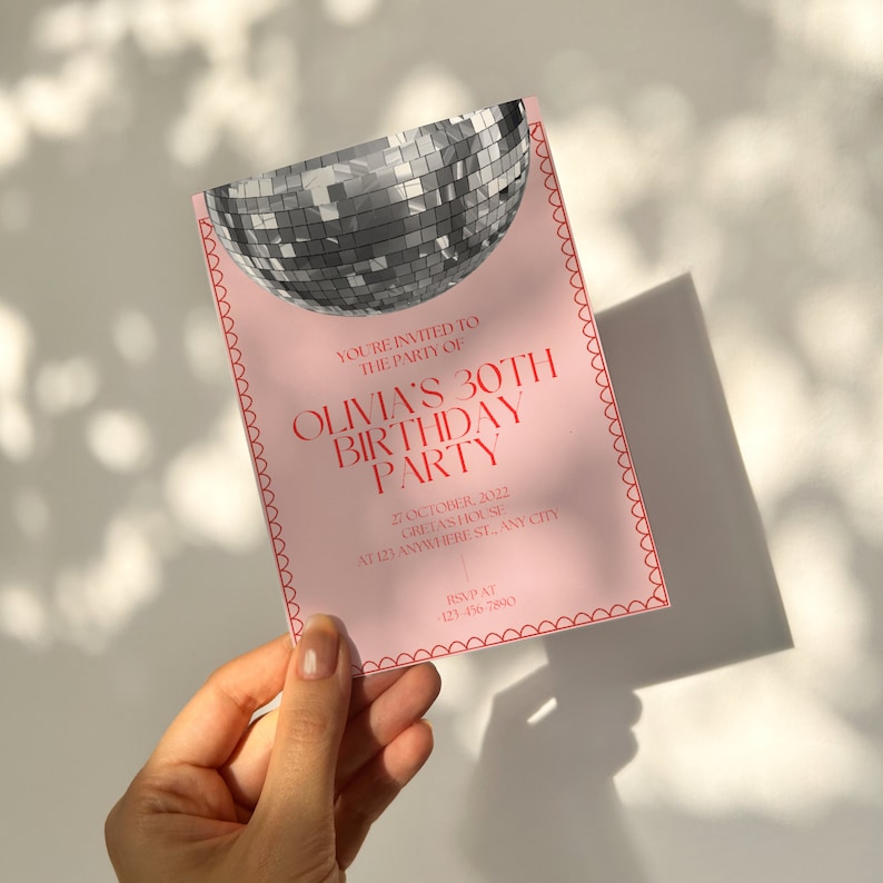 May include: Pink birthday party invitation with a silver disco ball graphic. The text reads "You're invited to the party of Olivia's 30th Birthday Party" with the date, location, and RSVP information below.