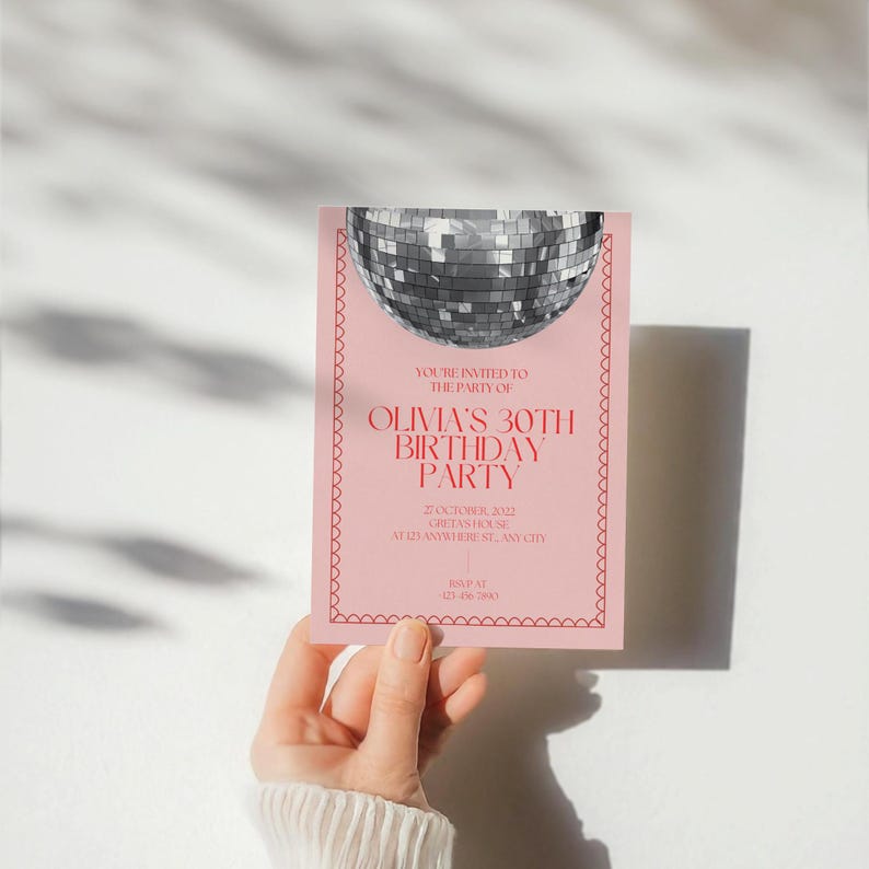 May include: Pink invitation with a silver disco ball graphic. The text reads "You're invited to the party of Olivia's 30th Birthday Party" with the date and location listed below.