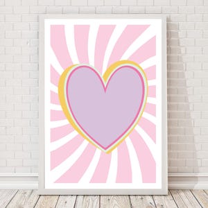 May include: A framed art print featuring a large purple heart with a yellow and pink outline, set against a background of pink and white radiating stripes. The artwork is displayed in a white frame.