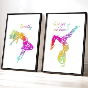 May include: Two framed art prints featuring dancers in vibrant rainbow colors. One print says "Dorothy" above a dancer. The other says "Just get up and dance!" above a dancer doing a handstand. Both prints have black frames.