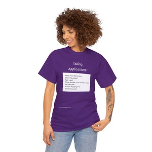 May include: A purple t-shirt with the text "Taking Applications" and a mock application form. The form includes fields for name, date, age, phone number, and position applying for. The shirt is worn by a person.