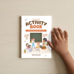 May include: A white activity book with the title "The Ultimate Activity Book" in brown letters. The cover illustration shows children in a classroom setting. The text "Color, Draw, Play & Explore Every Page" is below the title. The author's name, Hannah Morales, is at the bottom.