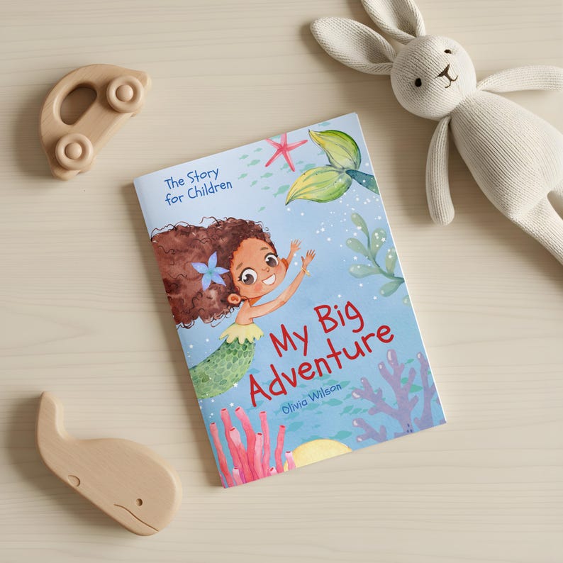 May include: A children's book titled "My Big Adventure" featuring a mermaid illustration. The book is surrounded by wooden toys, including a car, a whale, and a stuffed bunny.