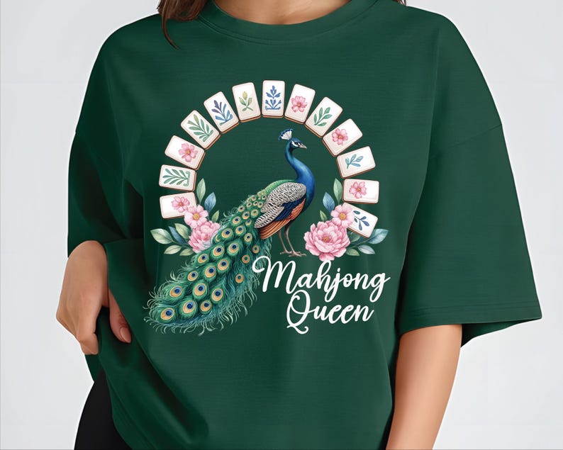 May include: Dark green sweatshirt featuring a peacock design with a floral and tile arch. The peacock has blue, green, and orange feathers. The text "Mahjong Queen" is written in white script below the peacock.