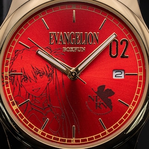 Pu&ograve; includere: Orologio da polso dorato con quadrante rosso. Il quadrante presenta la scritta "EVANGELION", un'illustrazione di un personaggio, il numero "02", un datario e il logo "NERV". Ha lancette dorate e un cinturino nero. Un accessorio elegante.