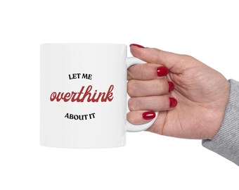May include: White ceramic mug with black text that reads "Let me overthink about it" in a red cursive font.