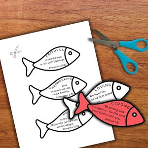 May include: A white paper with fish-shaped cutouts, each with a word and Bible verse. One fish is red. Blue scissors are on a wooden surface.