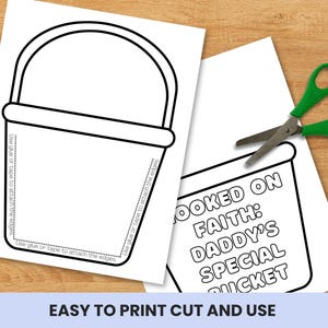 May include: Two white sheets of paper with black outlines of a bucket and text. One sheet has a bucket outline with instructions to glue or tape the edges. The other sheet has the text "HOOKED ON FAITH: DADDY'S SPECIAL BUCKET". A pair of green scissors is also present.