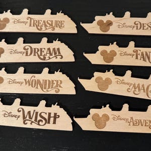 May include: Wooden cruise ship cutouts with the Disney logo and ship names: Treasure, Destiny, Dream, Fantasy, Wonder, Magic, Wish, and Adventure. The cutouts are light brown with dark brown engraved text and Mickey Mouse silhouettes.