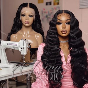 May include: Two black human hair wigs on mannequin heads. One wig is straight and the other is wavy. Both wigs are on a white sewing machine table. The text "Diva Studio" is visible on the table.