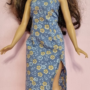 May include: A blue and yellow floral print strapless dress with a side slit. The dress is made for a doll.