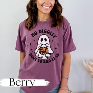 May include: A purple t-shirt with a ghost holding a jack-o-lantern and the text "No Diggity Bout To Bag It Up".