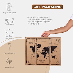 K&ouml;nnte beinhalten: Ein brauner Kartonkoffer mit einem schwarz-wei&szlig;en Weltkarten-Design. Der Koffer hat einen Griff und ist mit "Wooden World Map" beschriftet. Der Text "Great gift for adventurers & travellers" ist auf den Koffer gedruckt.