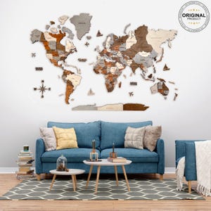 K&ouml;nnte beinhalten: Eine Weltkarte aus Holz mit einem Kompass und einem blauen Sofa im Vordergrund. Die Karte ist aus verschiedenen Holzschattierungen gefertigt und hat einen hellgrauen Hintergrund. Das Sofa ist hellblau und hat zwei Kissen. Die Karte h&auml;ngt an einer wei&szlig;en Wand.