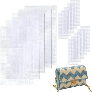 May include: A collection of white plastic canvas sheets in various rectangular sizes, alongside a small, light blue and cream-colored handbag with a gold chain strap and clasp. The handbag features a chevron pattern.