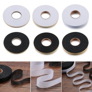 May include: An assortment of adhesive tapes in rolls. The image shows rolls of white and black tape, some with a textured surface. The tape is designed for various applications, offering a practical solution for different needs.