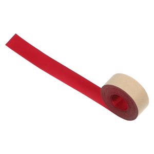 May include: A roll of red ribbon with a brown paper core. The ribbon is unwound, showing a long, flat strip of the vibrant red material. The roll is positioned at an angle against a white background.