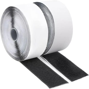 May include: Two rolls of white hook and loop tape with black hook and loop strips extending from the rolls. The rolls are tightly wound, showing the white backing. The black strips are textured and ready for use.