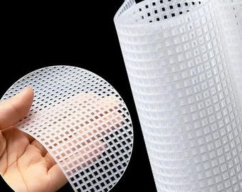 Könnte beinhalten: Nahaufnahme von weißen Kunststoff-Leinwandbögen mit einem Rastermuster. Ein Bogen wird von einer Hand gehalten, was die Flexibilität des Materials zeigt. Der Hintergrund ist schwarz und hebt die Textur und Struktur der Leinwand hervor.