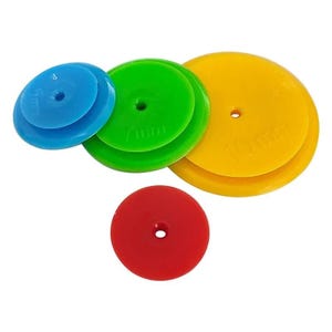 May include: Four round plastic cake decorating tools in different colours: blue, green, yellow, and red. The tools are stacked on top of each other, with the largest tool on the bottom and the smallest tool on top. The tools have a hole in the centre and are labelled with their diameter in millimetres: 55mm, 70mm, 100mm, and 50mm.