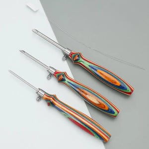 May include: Three hand tools with stainless steel shafts and colorful, striped wooden handles. The handles feature a mix of red, green, blue, and orange hues. The tools have a pointed tip and a small adjustment screw near the handle.