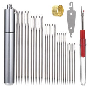 Peut inclure: Un kit de couture comprenant un tube de rangement en métal argenté, vingt-six aiguilles à coudre en acier, un dé à coudre en métal doré, un enfile-aiguille en métal argenté et un découd-vite avec un manche rouge et un capuchon transparent.