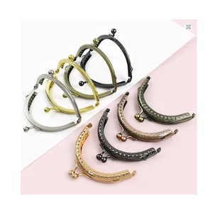 May include: A collection of metal purse frames in various colors, including gold, silver, bronze, and black. The frames have a curved shape with decorative ball closures and are arranged on a white and pink background.