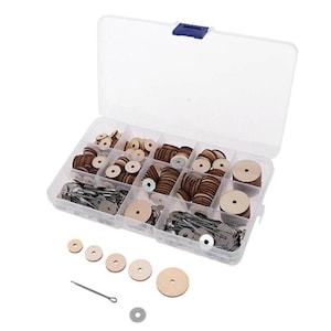 Puede incluir: Una caja organizadora de plástico transparente llena de varios discos de madera, sujetadores metálicos y otros componentes de hardware pequeños. Los discos de madera son de color marrón claro con un agujero en el centro. La caja está abierta.