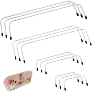 Puede incluir: Un conjunto de asas de bolso de metal plateado de varios tamaños, con puntas negras. También se ve un bolso de tela rosa estampada. Estas asas están diseñadas para proyectos de manualidades y fabricación de bolsos.