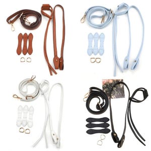 Peut inclure: Un assortiment de lanières et d'accessoires de sacs en cuir de différentes couleurs. L'image présente des lanières marron, bleu clair, blanches et noires, ainsi que du matériel assorti comme des fermoirs, des rivets et des connecteurs. Idéal pour les projets de sacs DIY.