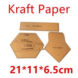 May include: Kraft paper pattern pieces for a craft project. The pieces are brown and have dotted lines around the edges. The pattern includes a hexagon, a diamond shape, and a rectangle. The text "AAB-453" is printed on the pieces. The dimensions of the pattern are 21 inches by 11 inches by 6.5 inches.