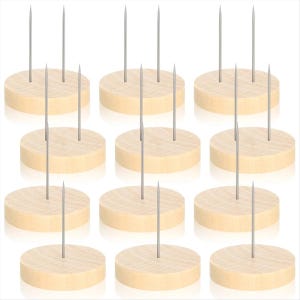 Könnte beinhalten: Eine Ansammlung von zwölf Holz-Pinhaltern, jeweils mit einer kreisförmigen Basis und drei silbernen Metallstiften. Das Holz hat eine helle, natürliche Farbe, und die Stifte sind gleichmäßig verteilt. Die Artikel sind in einem Raster angeordnet.