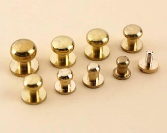 May include: A collection of brass-colored rivets and fasteners. The assortment includes various sizes of domed rivets and a screw-post rivet, all with a shiny, metallic finish. These hardware pieces are likely for leathercraft or similar projects.