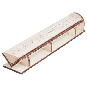 May include: A wooden cribbage board with a natural finish. The board has a long, angled playing surface with numbered holes for pegs. The sides and base are also made of wood, creating a sturdy structure for the game.