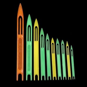 以下が含まれることがあります： オレンジ、緑、黄色など、さまざまなサイズと色のプラスチック製の織り針のコレクション。針は細長いデザインで、中央にスロットがあり、先端が尖っています。一部の針には漢字が印刷されています。