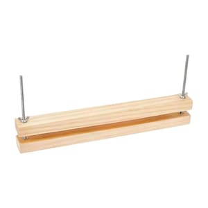 May include: A wooden embroidery frame featuring two parallel wooden bars secured by metal screws and wing nuts. The natural wood contrasts with the silver hardware. The design is simple and functional.