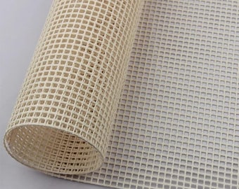 May include: A roll of white plastic canvas mesh, used for needlepoint and other crafts. The canvas is rolled up and the mesh is visible.